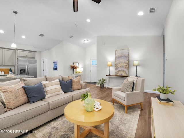 living room with ceiling fan, vaulted ceiling, and hardwood / wood-style floors