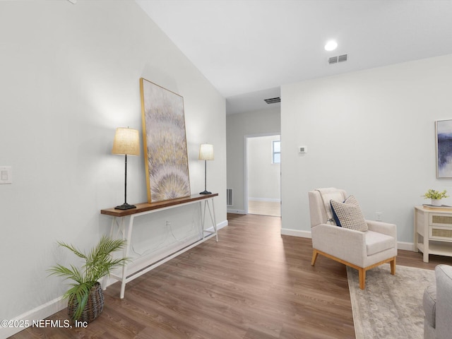 living area with vaulted ceiling and wood-type flooring