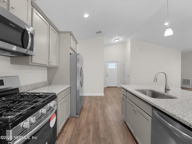 kitchen with light stone countertops, sink, appliances with stainless steel finishes, and gray cabinetry