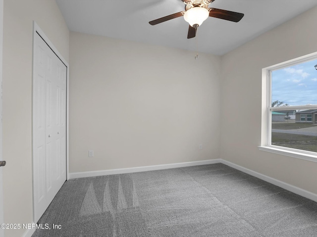 unfurnished bedroom featuring carpet floors, ceiling fan, a closet, and multiple windows