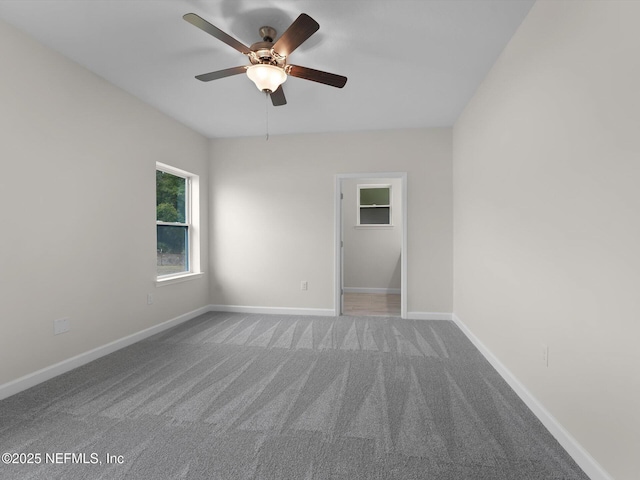 carpeted spare room featuring ceiling fan