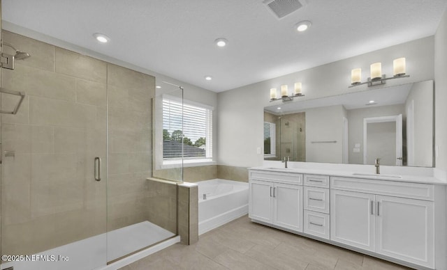 bathroom with vanity and independent shower and bath