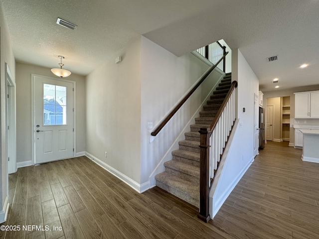 entrance foyer featuring dark hardwood / wood-style floors and a textured ceiling