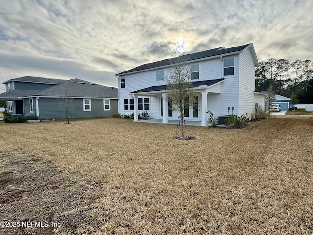 rear view of property with a patio, a yard, and central AC unit