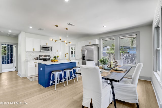 dining space featuring plenty of natural light and light hardwood / wood-style flooring