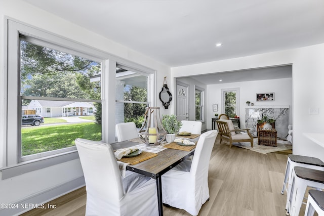 dining area with a premium fireplace and light hardwood / wood-style flooring