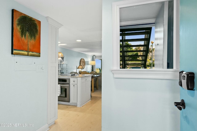 interior space with ornamental molding and light hardwood / wood-style flooring