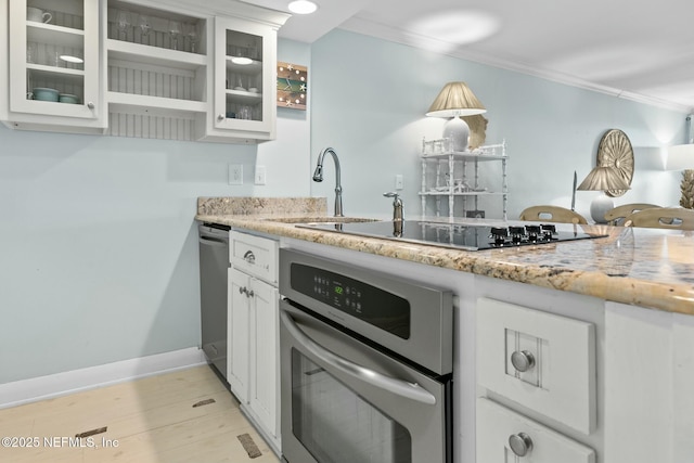 kitchen featuring oven, white cabinets, crown molding, and black electric cooktop