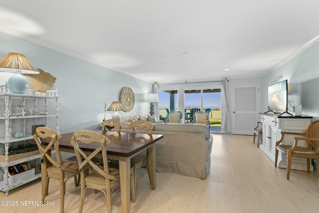 dining area with light wood-type flooring and crown molding