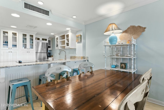 dining area featuring sink and ornamental molding