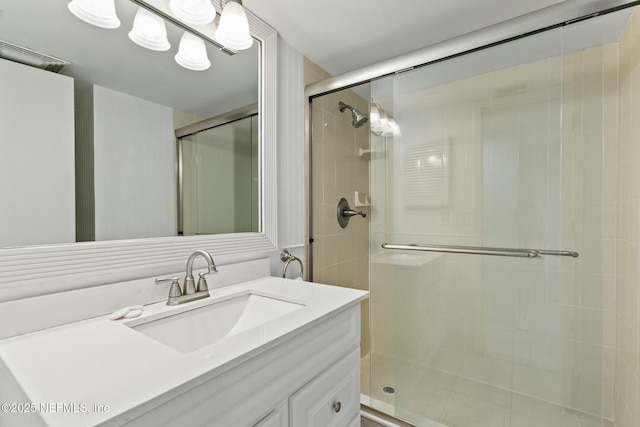 bathroom featuring vanity and a shower with shower door