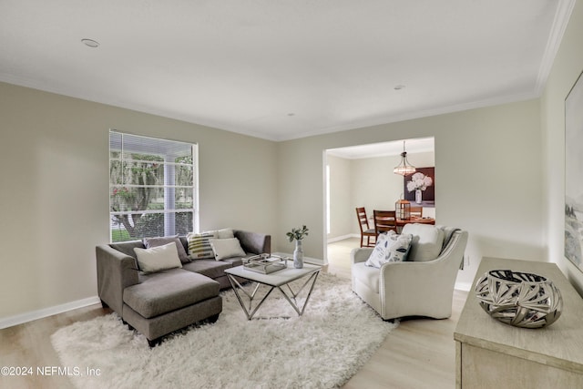 living room with an inviting chandelier, ornamental molding, and hardwood / wood-style flooring