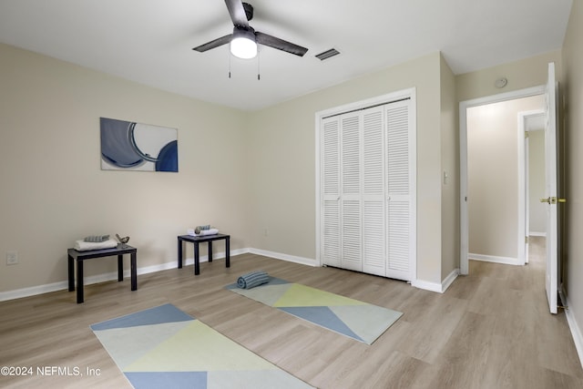 workout room featuring ceiling fan and light wood-type flooring