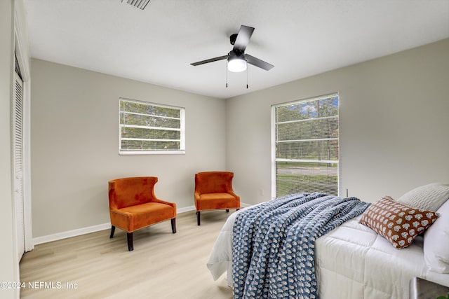 bedroom with ceiling fan, light wood-type flooring, and a closet