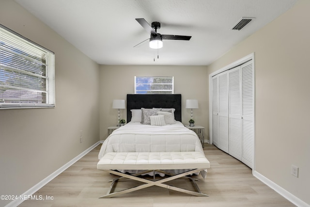 bedroom with ceiling fan, light hardwood / wood-style flooring, and a closet