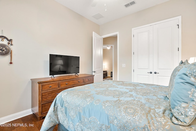 bedroom with dark wood-type flooring, ceiling fan, and a closet