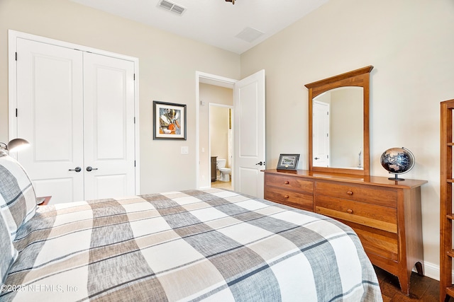 bedroom with dark hardwood / wood-style flooring and a closet