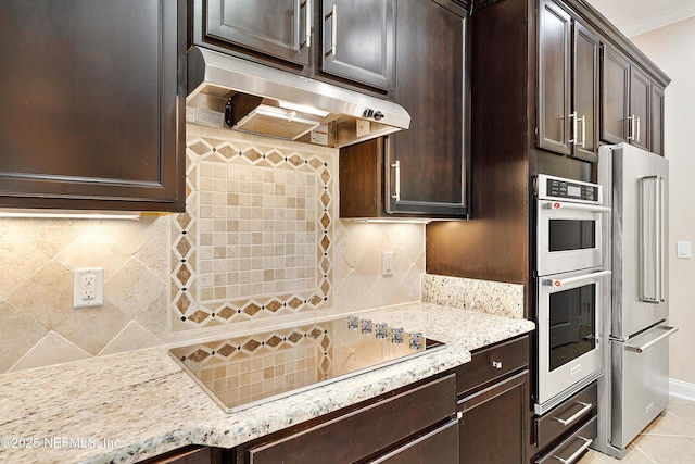 kitchen featuring stainless steel appliances, tasteful backsplash, and dark brown cabinetry