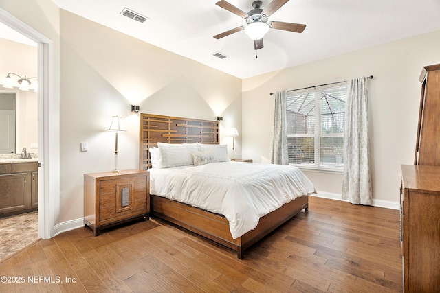 bedroom with hardwood / wood-style floors, ceiling fan, lofted ceiling, and connected bathroom