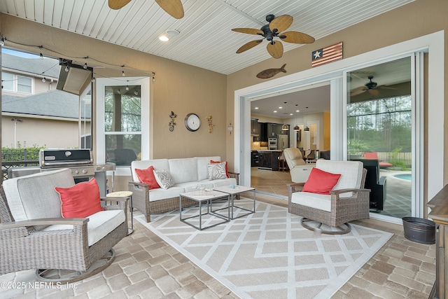 view of patio with ceiling fan, area for grilling, and an outdoor living space