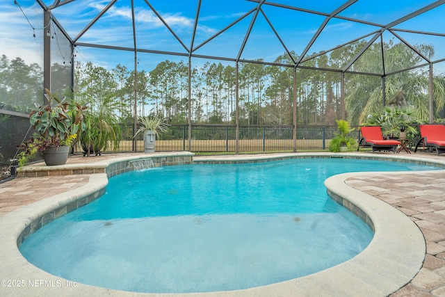 view of pool with pool water feature, glass enclosure, and a patio area