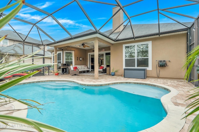 view of swimming pool with a lanai, a patio area, ceiling fan, and a grill