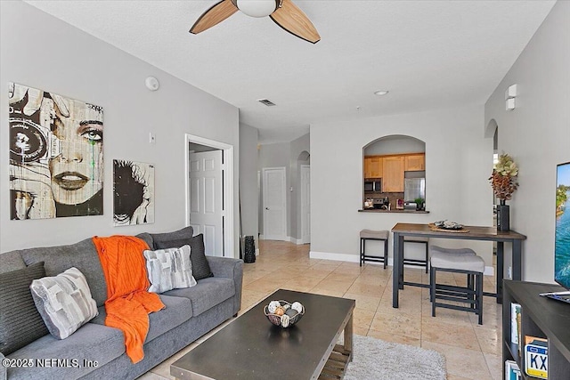 tiled living room with ceiling fan