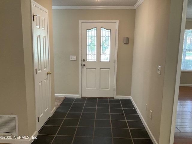 doorway with dark tile patterned floors and crown molding