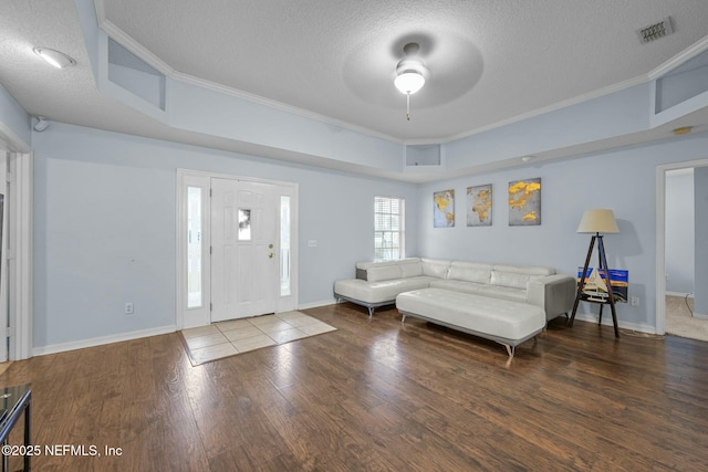 living room featuring a textured ceiling, ornamental molding, ceiling fan, and dark wood-type flooring