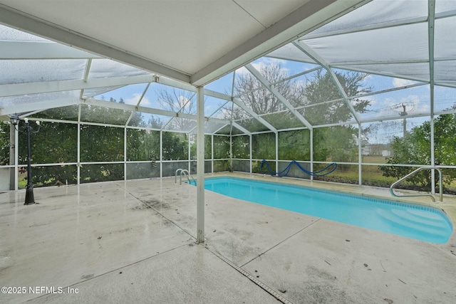 view of swimming pool with glass enclosure and a patio