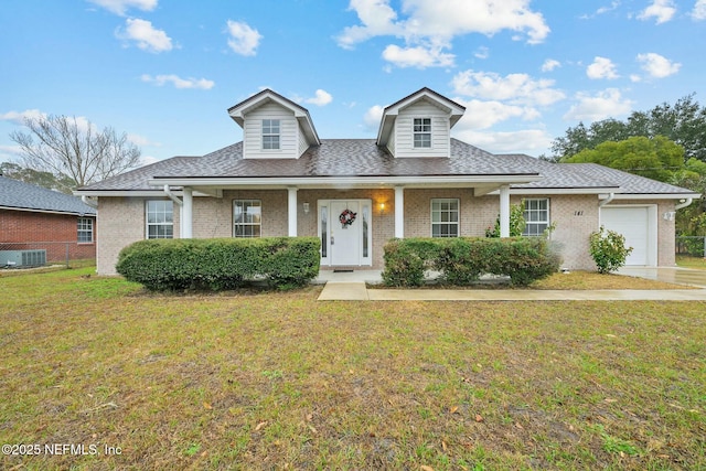 view of front of house with a porch, central air condition unit, a front lawn, and a garage