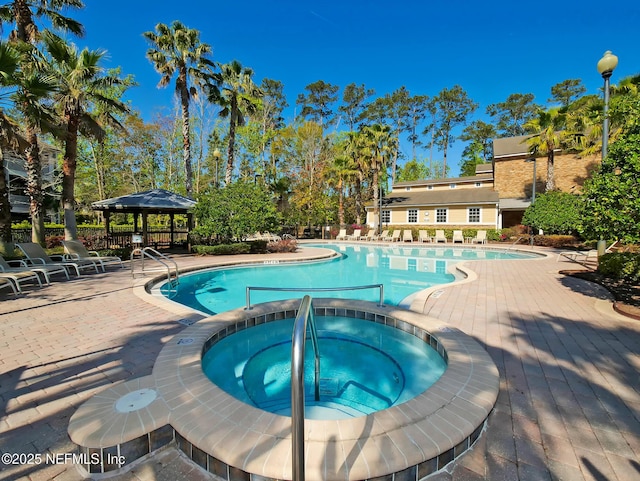 view of swimming pool with a gazebo and a hot tub