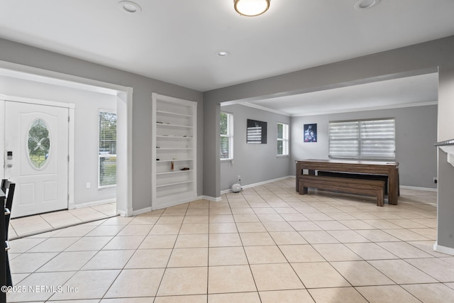 tiled foyer entrance with crown molding