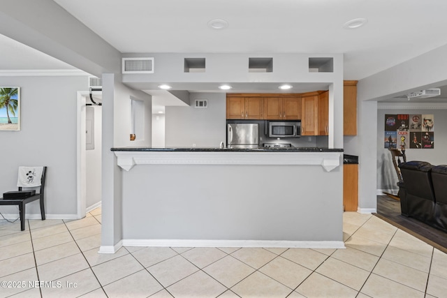 kitchen featuring light tile patterned floors, stainless steel appliances, and crown molding