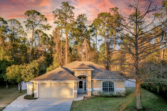 ranch-style house featuring a lawn and a garage