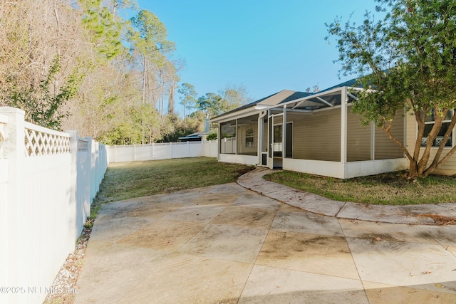 exterior space with a lanai, a lawn, a sunroom, and a patio area