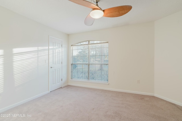 empty room featuring light carpet and ceiling fan