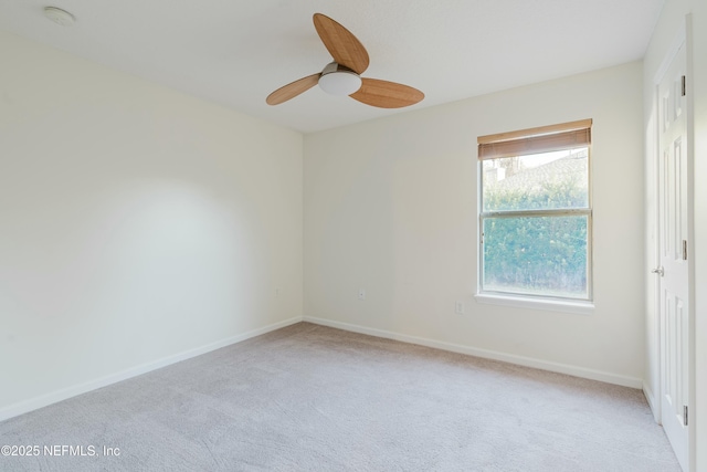 carpeted spare room with ceiling fan