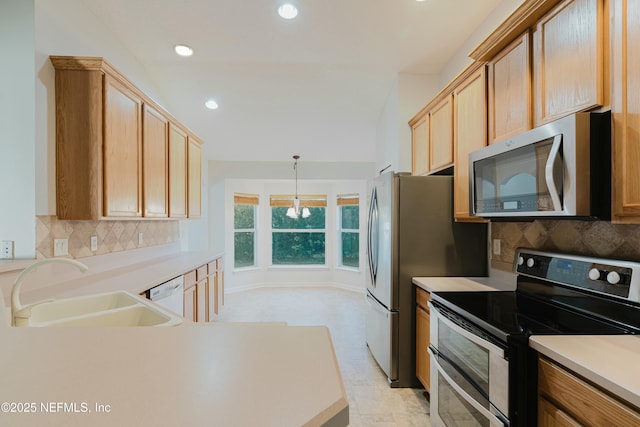 kitchen featuring an inviting chandelier, appliances with stainless steel finishes, backsplash, and sink