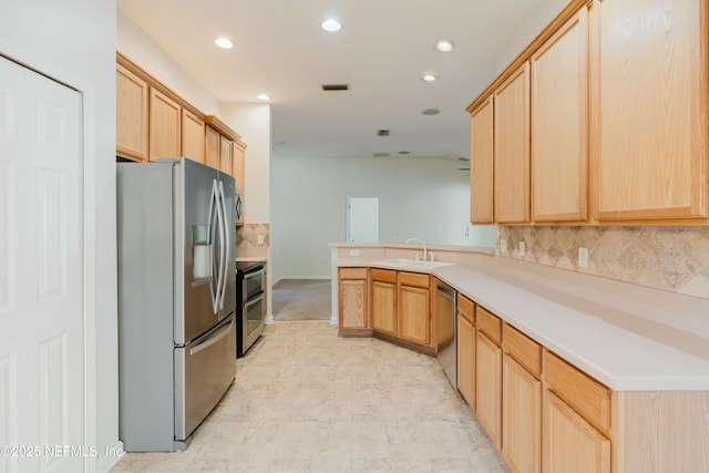 kitchen featuring stainless steel appliances, sink, light brown cabinets, kitchen peninsula, and decorative backsplash