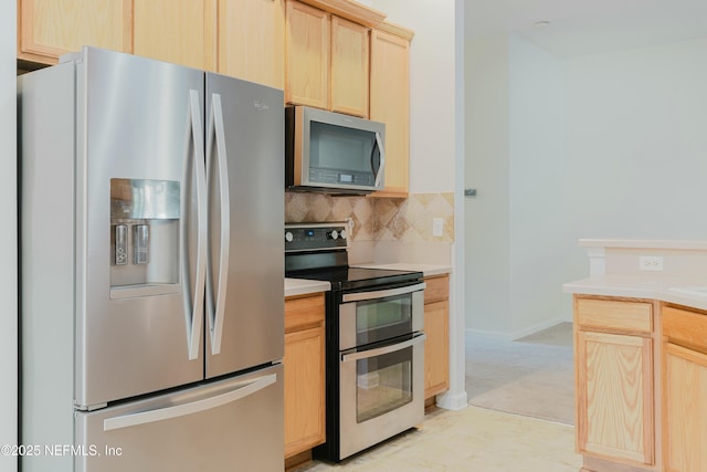 kitchen with appliances with stainless steel finishes, backsplash, and light brown cabinets