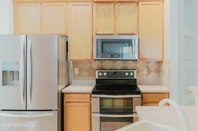 kitchen with stainless steel appliances, light brown cabinets, decorative backsplash, and sink