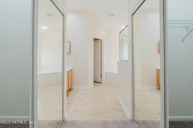 bathroom with a tub and vanity