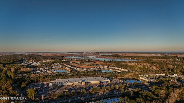 aerial view at dusk featuring a water view