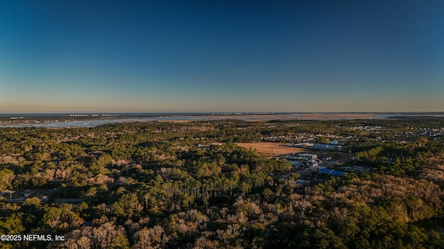 aerial view at dusk featuring a water view