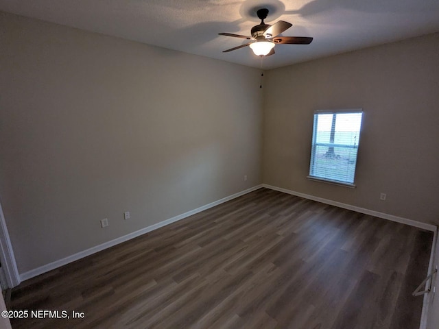 empty room with ceiling fan and dark hardwood / wood-style flooring