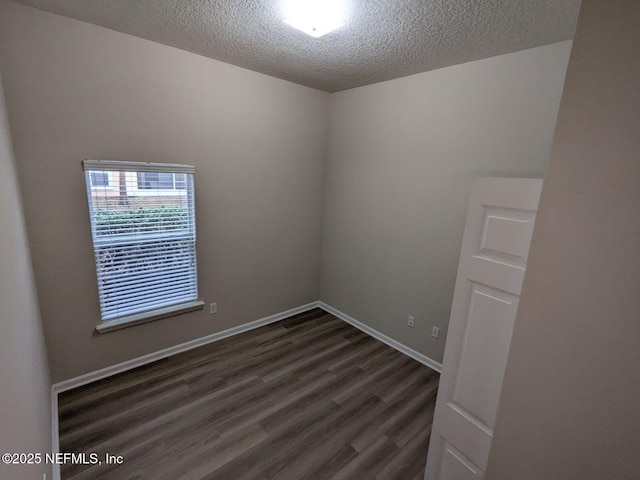 unfurnished room featuring a textured ceiling and dark wood-type flooring