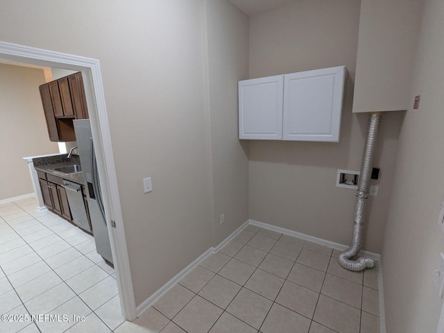 washroom with sink, washer hookup, cabinets, hookup for an electric dryer, and light tile patterned flooring