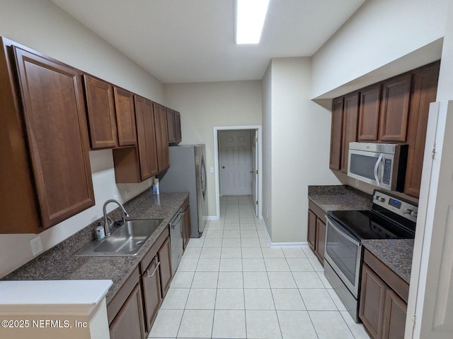 kitchen featuring sink, light tile patterned floors, and appliances with stainless steel finishes