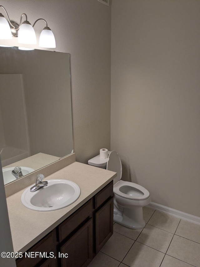 bathroom with toilet, vanity, and tile patterned floors